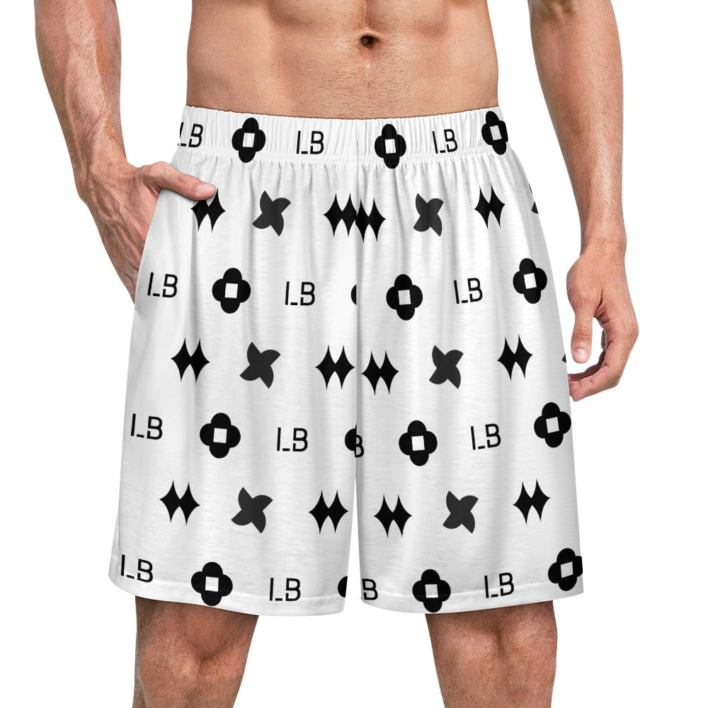 Man wearing white shorts with black geometric patterns and initials "I.B." scattered throughout.
