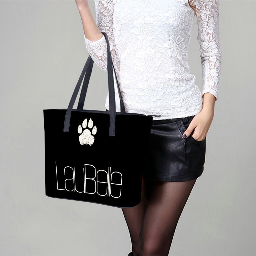 Woman in white lace top holds black tote with paw print and "La Bele" text.