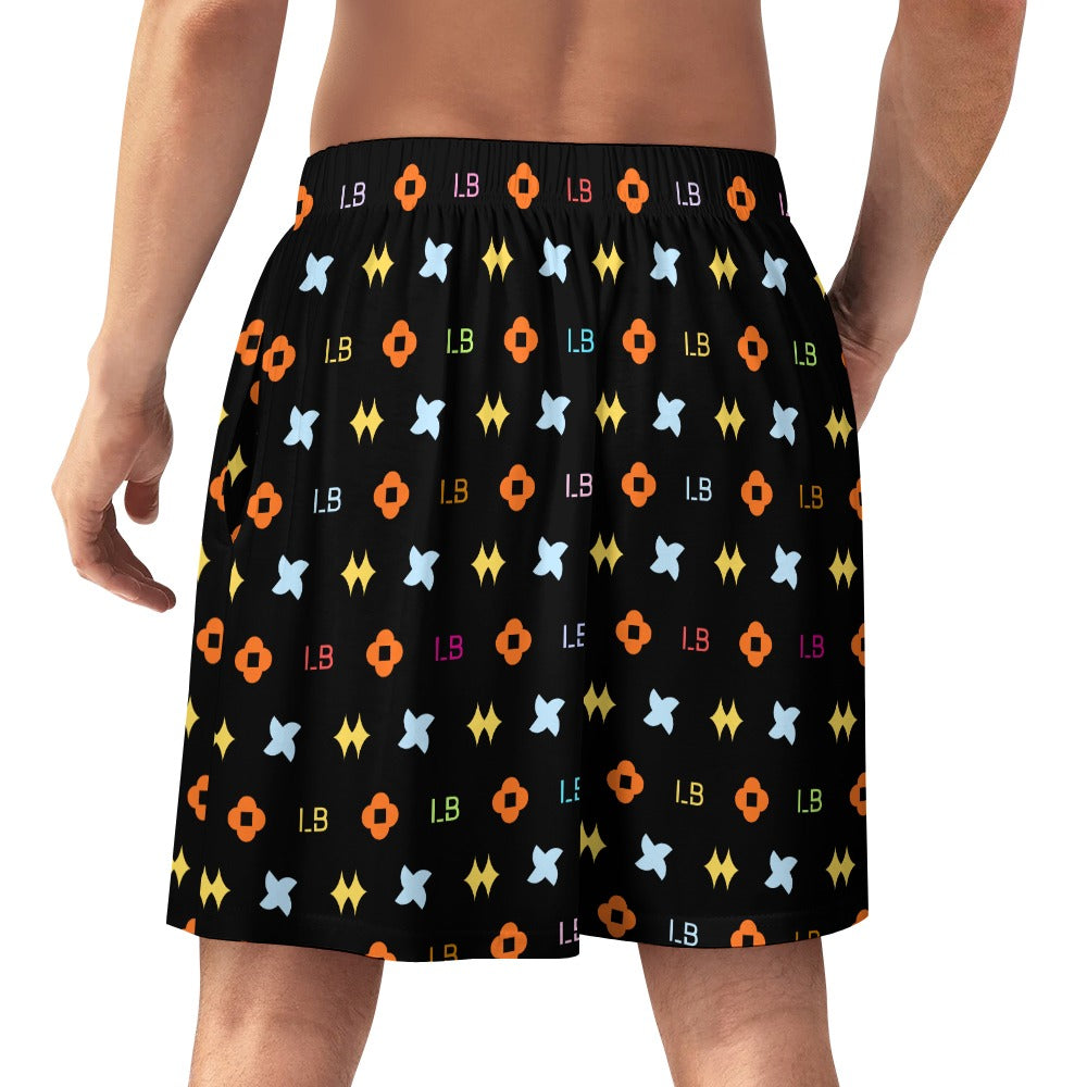 Man wearing black shorts with colorful geometric patterns and letters.