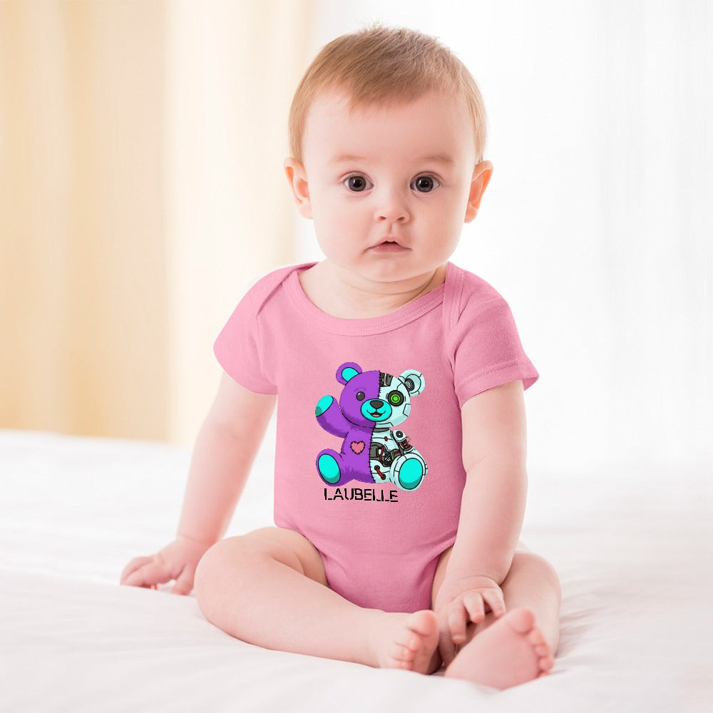 Baby in pink onesie with colorful cartoon bear, seated on white bed, light background.