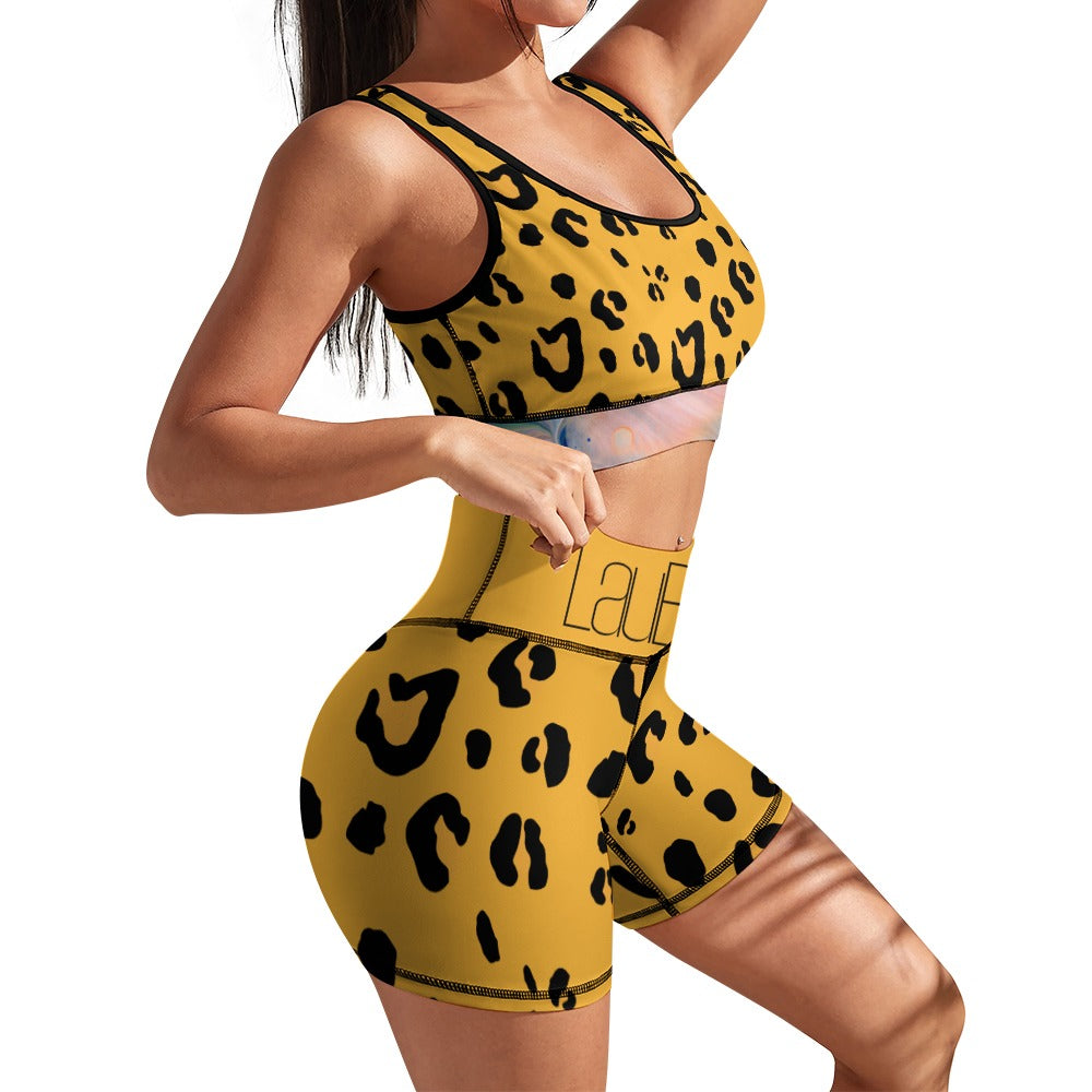 Woman in a yellow leopard-print sports outfit, posing with arms bent and one leg forward.