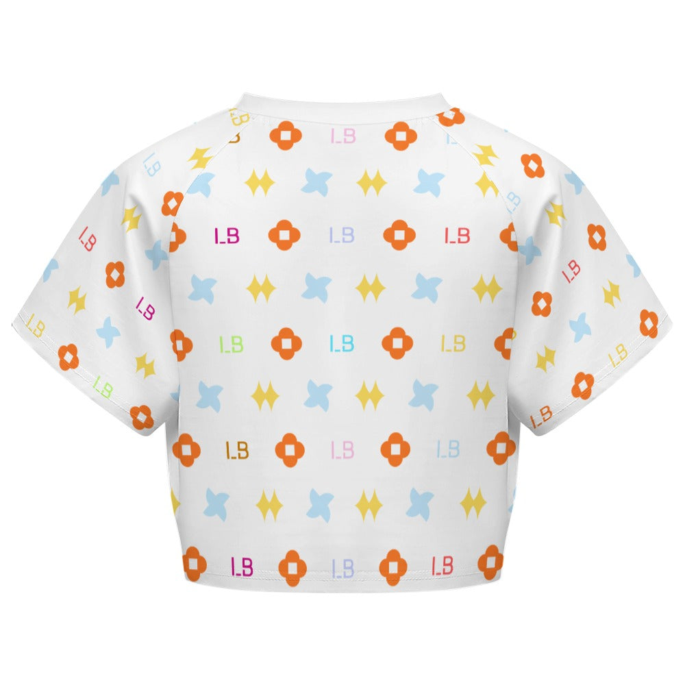 White shirt with colorful patterns: orange flowers, blue stars, yellow shapes, and "LB" initials.