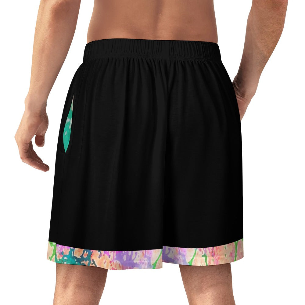 Man wearing black shorts with colorful splatter trim, viewed from the back, hand by side.