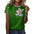 Woman in green shirt with colorful bear design and patterned sleeves, wearing jeans.