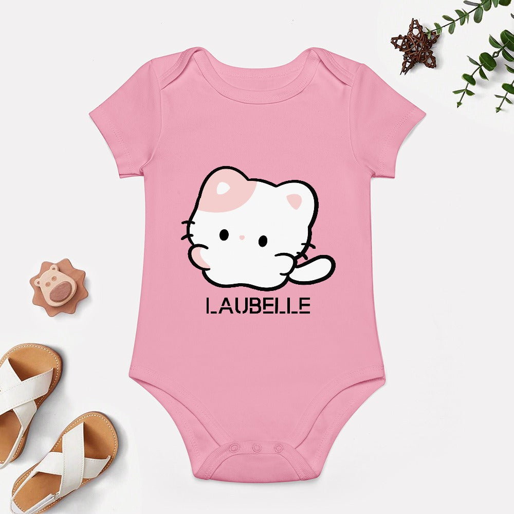Pink baby onesie with a cute white cat and "LAUBELLE" text, surrounded by toys and sandals.