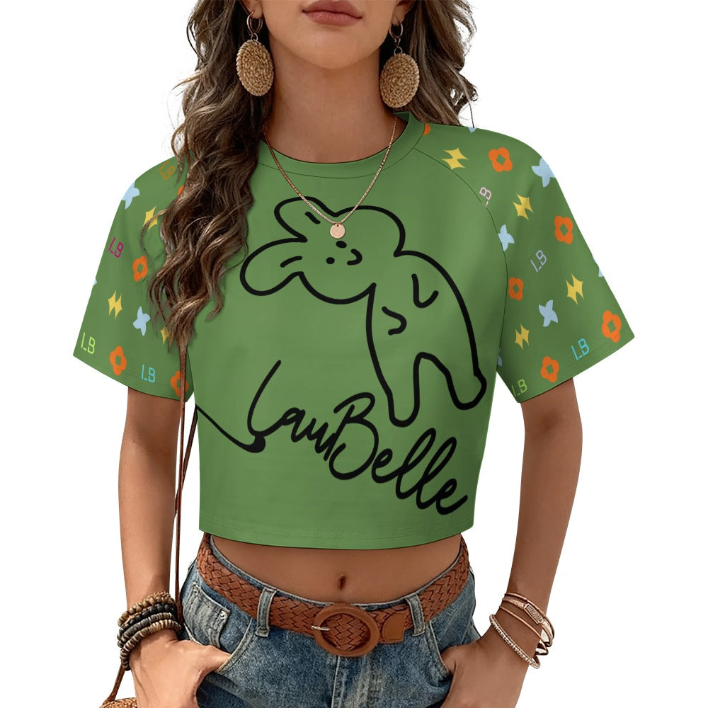 Woman in green crop top with cartoon rabbit, colorful patterns, denim shorts, and hoop earrings.