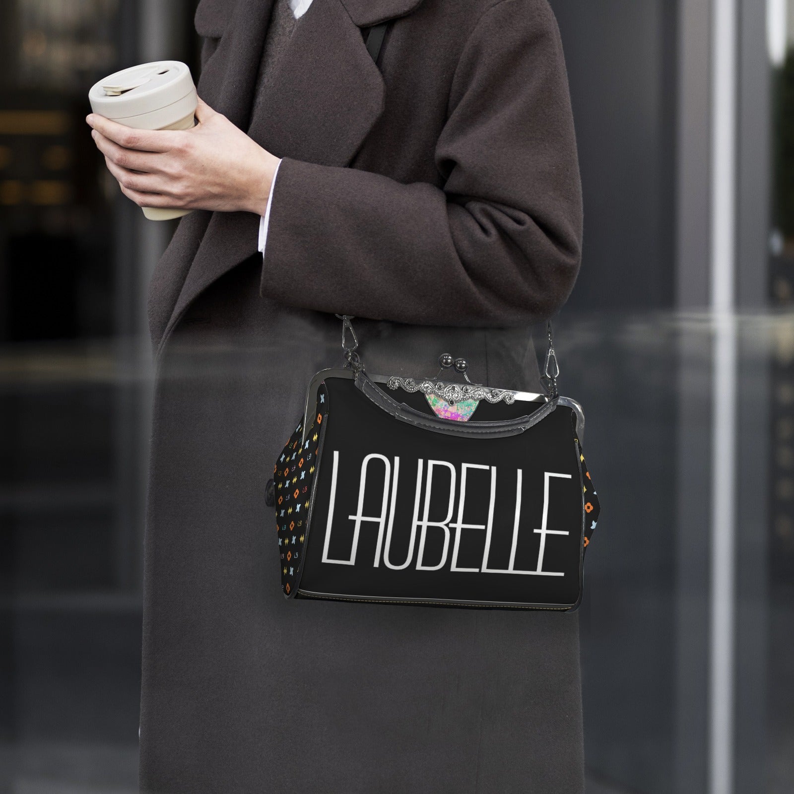 Person in dark coat holding coffee cup and black bag with "LAUBELLE" text, colorful dots on sides.