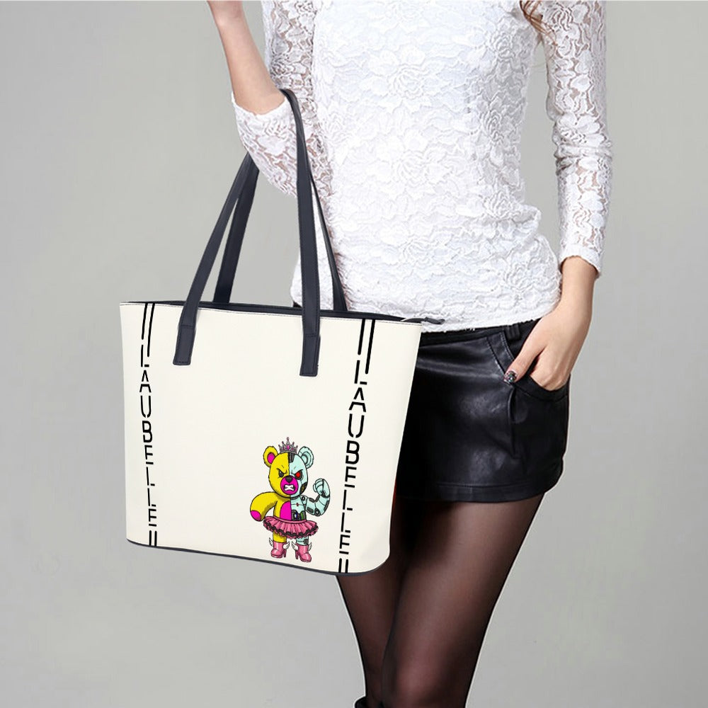 Woman holding a white tote bag with a colorful bear design, black straps, and black text.