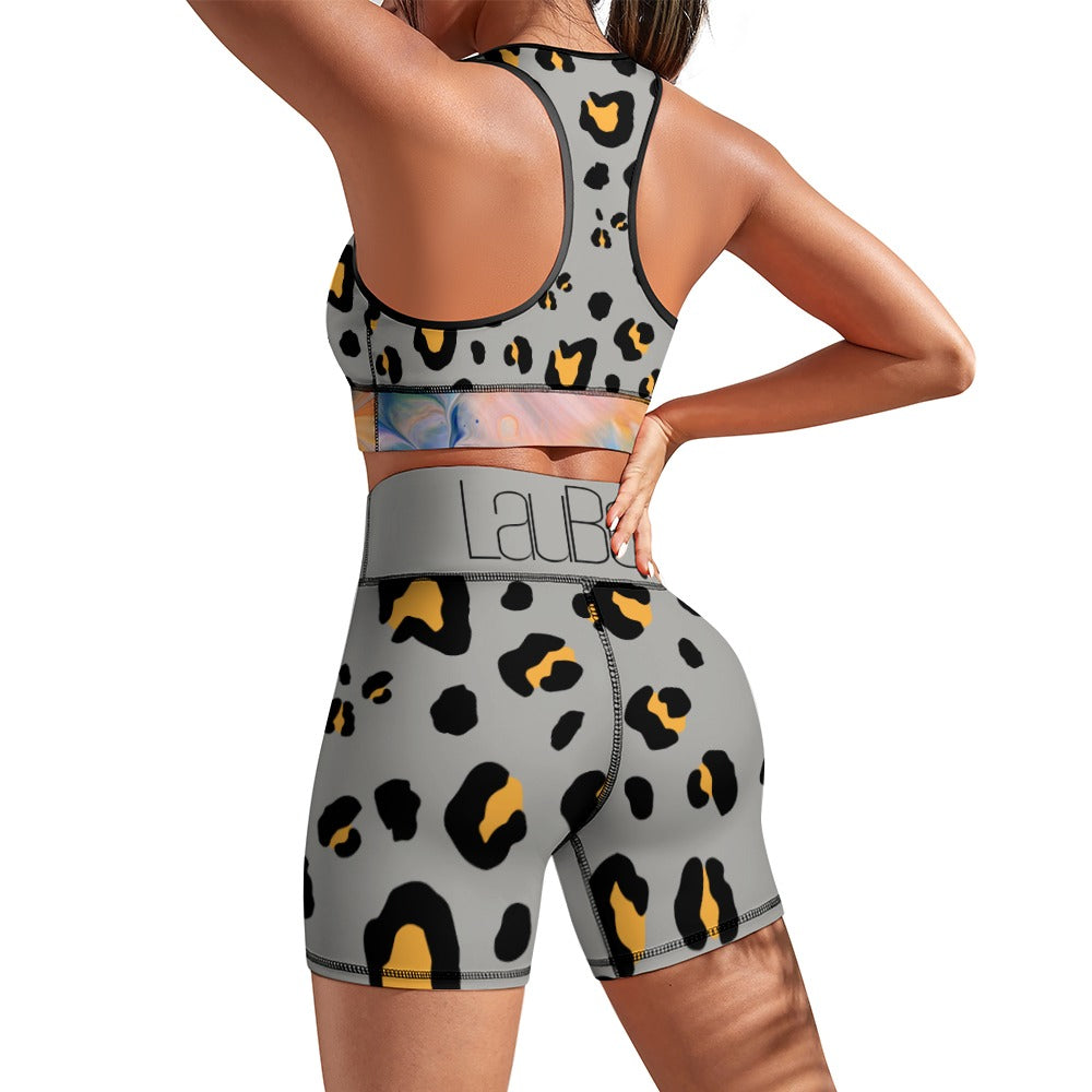 Woman in leopard-print athletic wear, gray with black and yellow spots, standing with hands on hips.
