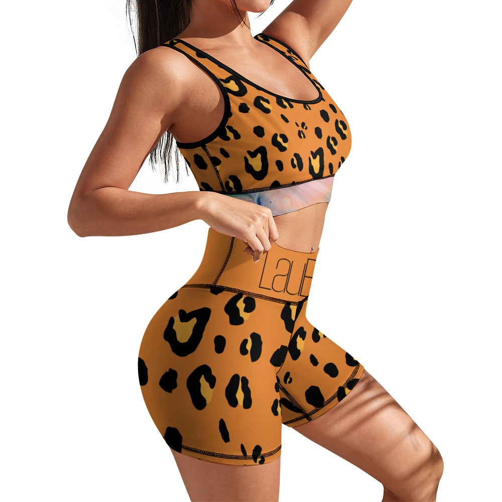 Woman in leopard print workout set, orange with black spots, posing with hands on hips.