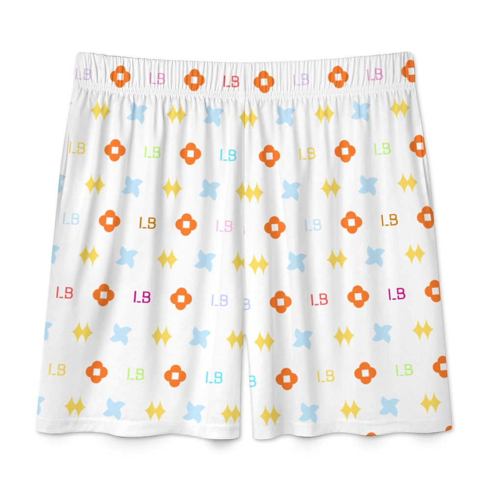 White shorts with a colorful pattern of orange, blue, yellow shapes, and letters on fabric.