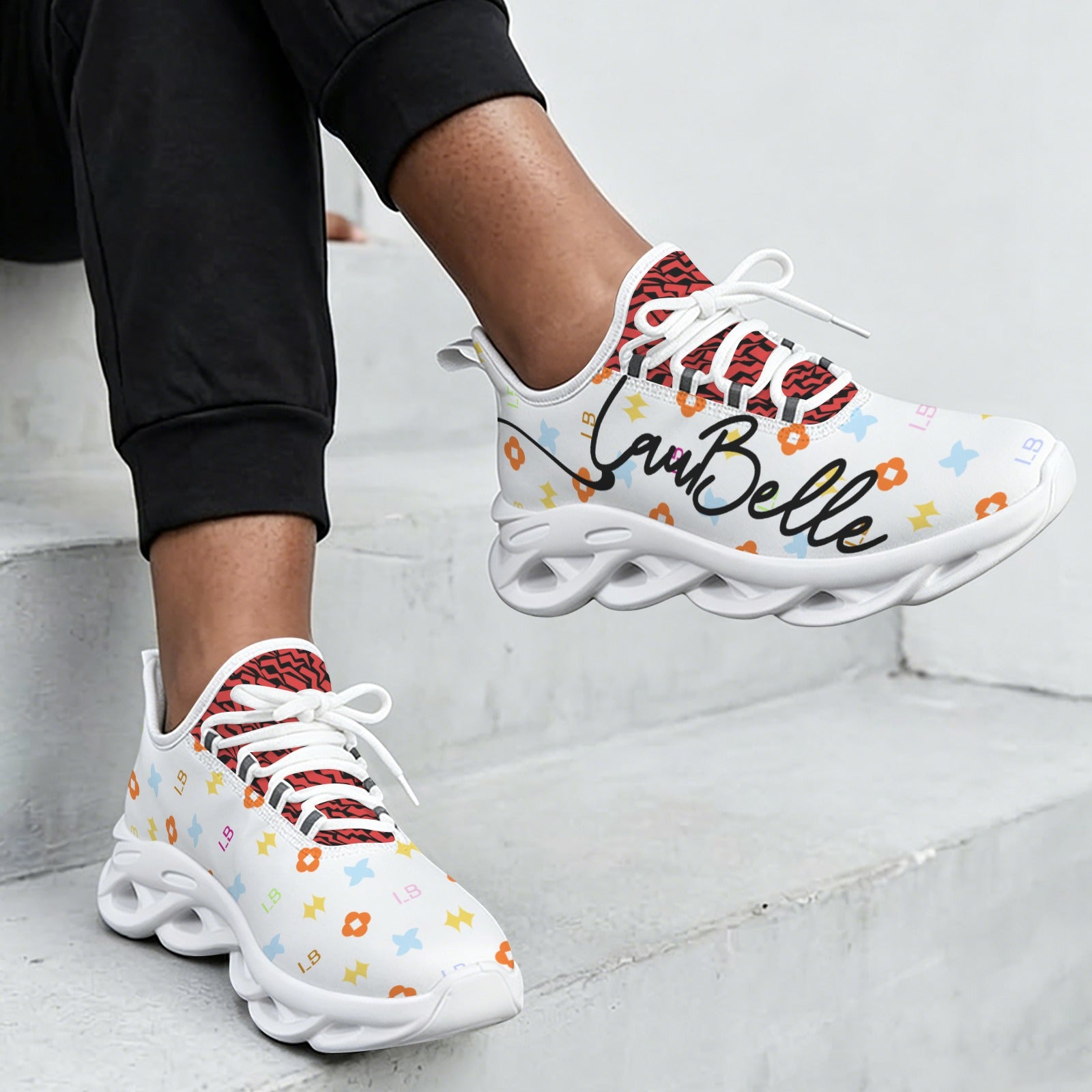 White sneakers with colorful patterns, red interior, and unique wavy soles.