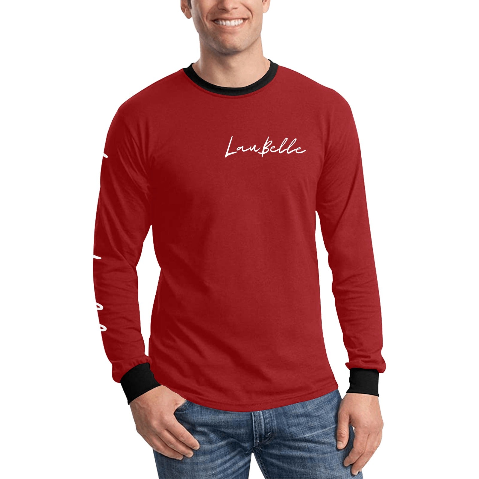 Man in red long-sleeve shirt with black cuffs, white text on chest, and blue jeans, smiling.