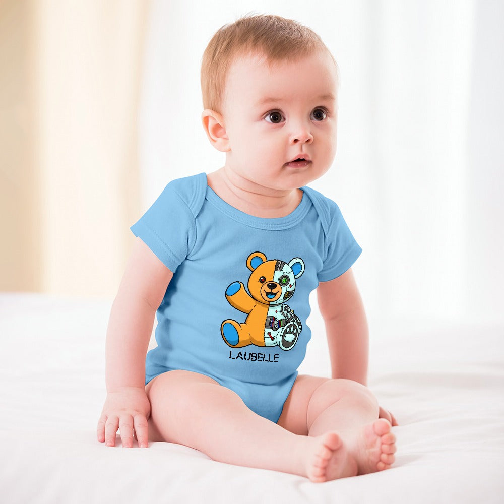 Baby in blue onesie with teddy bear design, sitting on white bed with light background.