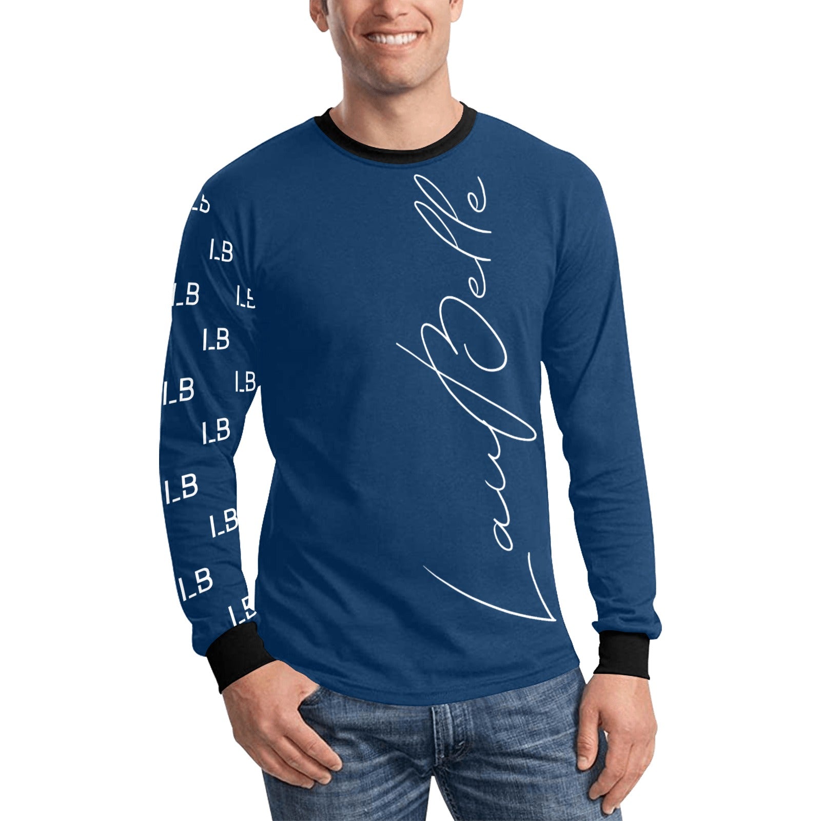 Man in blue long-sleeve shirt with white script text, black cuffs, and jeans, smiling.