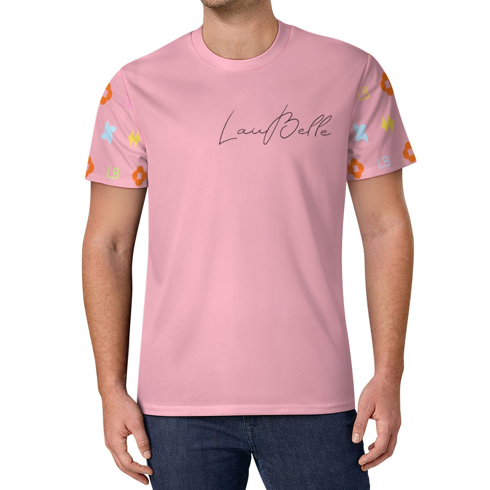 Man in pink T‑shirt with cursive logo and colorful floral sleeves, wearing dark jeans.