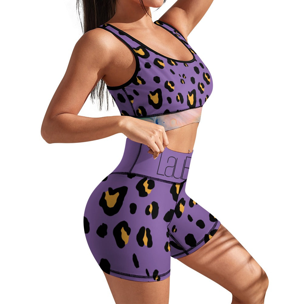 Woman in purple leopard print activewear set, posing with hand on hip.
